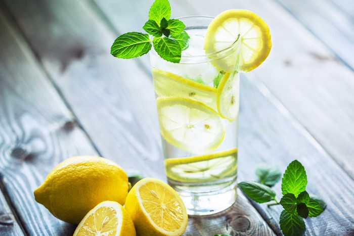 glass of water with lemon slices and mint