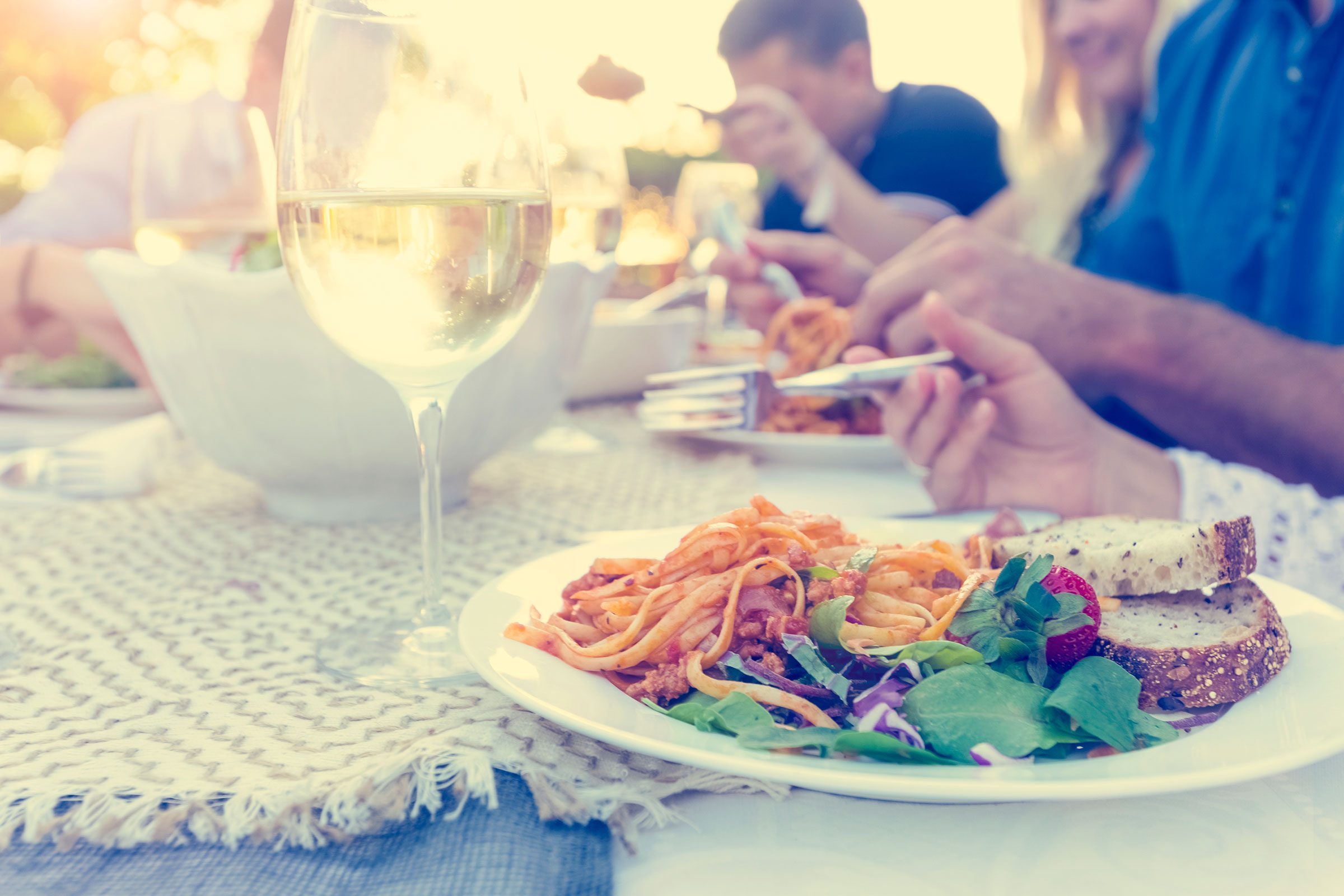 people eating salad with bread and glass of wine