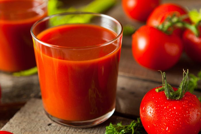 glasses of tomato juice surrounded by fresh tomatoes