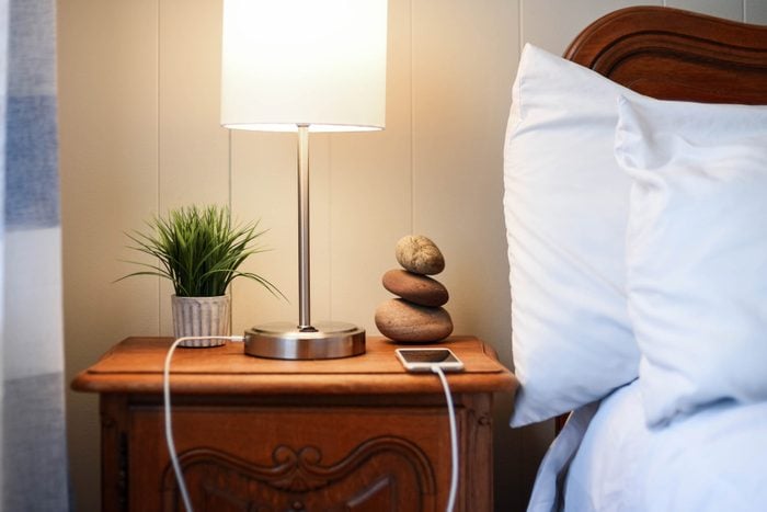 smarphone charging on nightstand next to bed