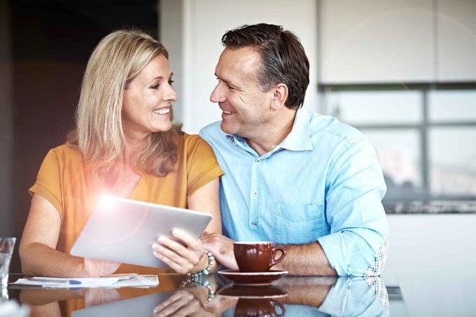 couple smiling over coffee and documents