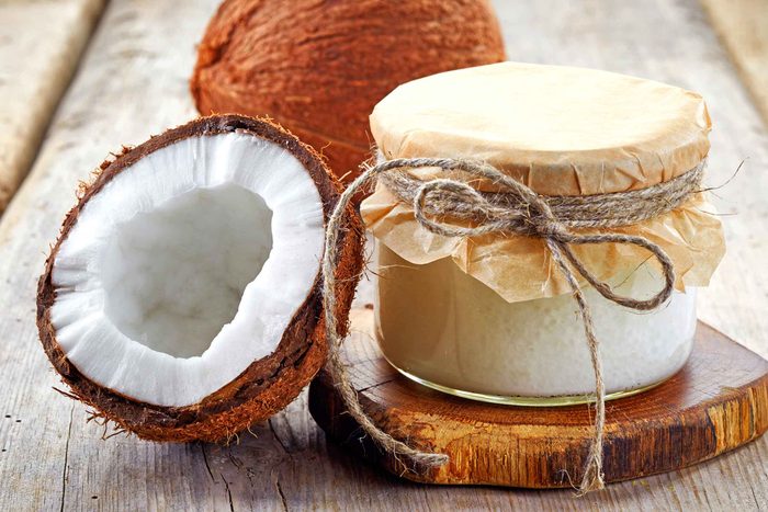 Container of coconut oil and raw coconut.