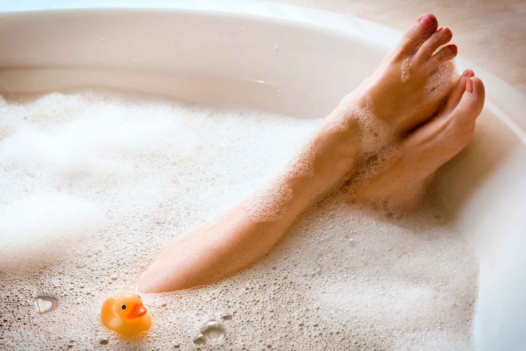 Woman's feet peaking out of a bubble bath.
