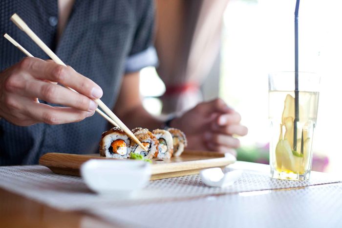 man eating sushi with chopsticks