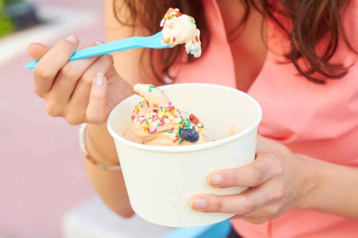 woman eating ice cream out of a large tub