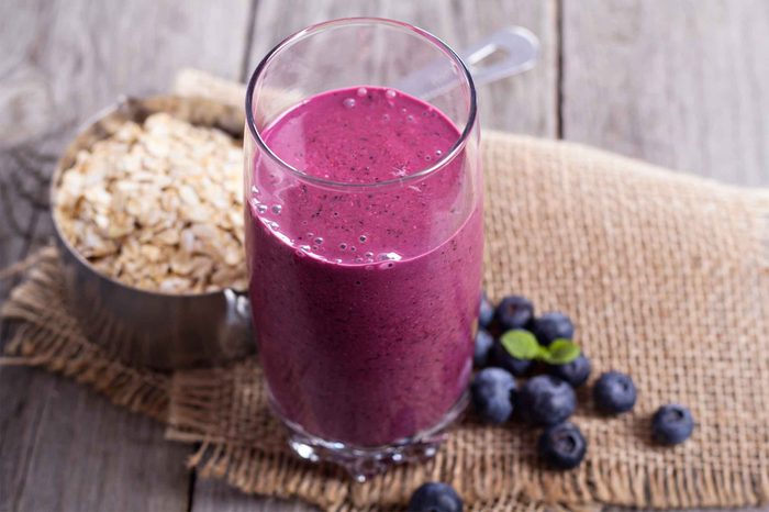 purple smoothie next to berries and oats