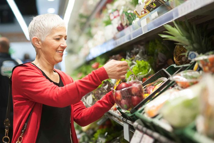 gray-haired woman shopping the produce aisle