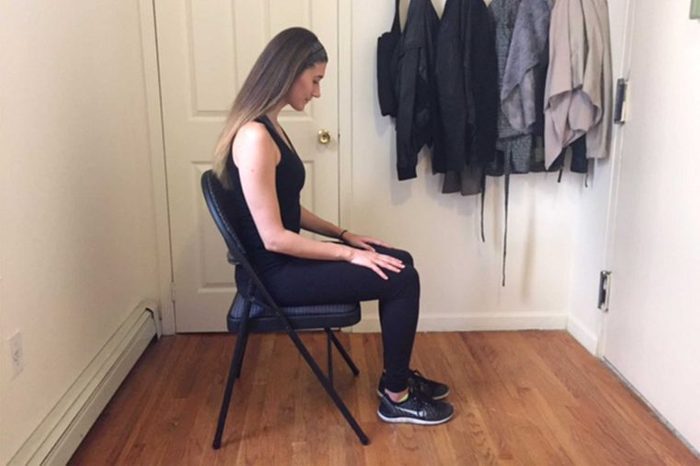Woman in workout gear doing a seated exercise.