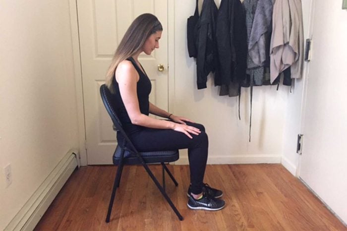 Woman in workout gear doing a seated exercise.
