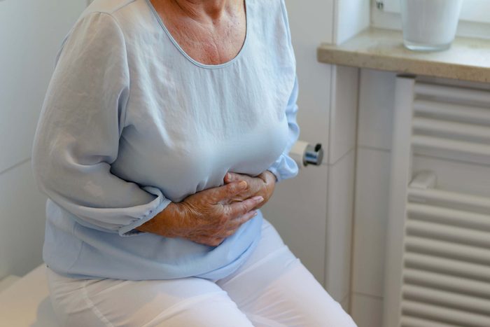 elderly woman holding her stomach