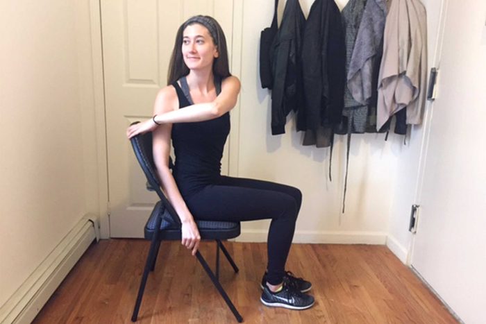 Woman doing a seated chair twist exercise.