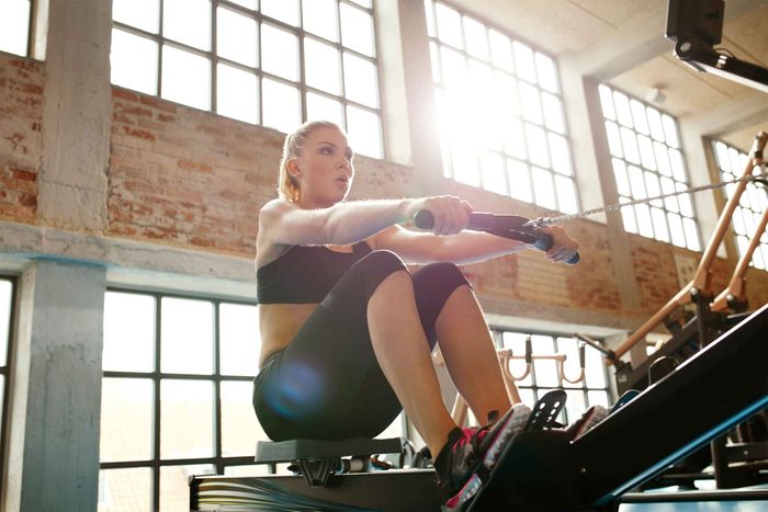 woman using rowing machine at gym