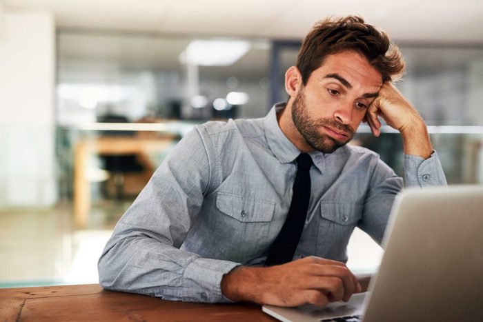 Man in front of computer, looking bored