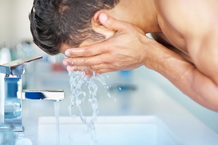 man washing his face in a skin