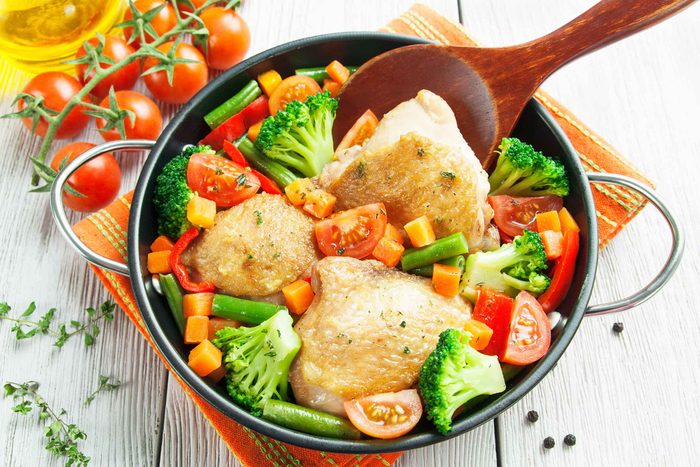 Chicken with broccoli, carrots and tomatoes in a casserole dish