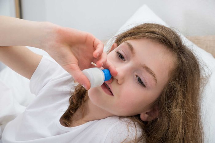 girl with nasal suction device to nose