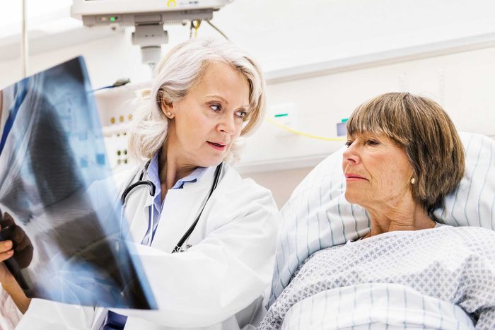 Female doctor discussing a scan result with her hospitalized patient.