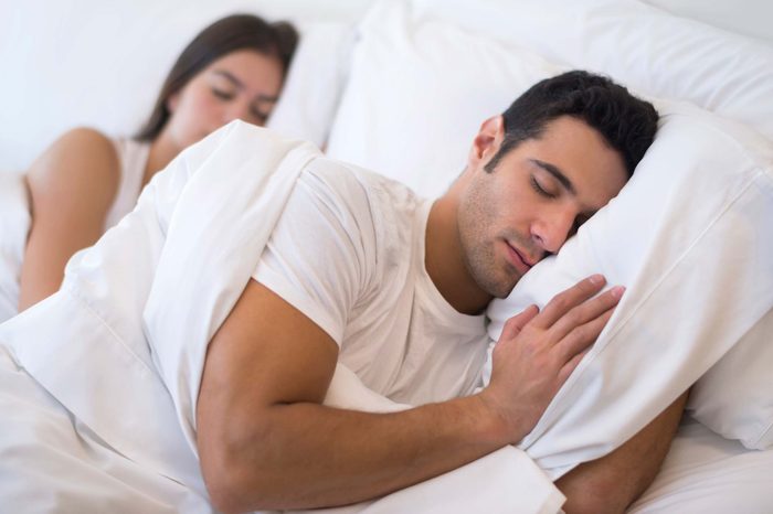 Man and woman sleeping with extra pillows