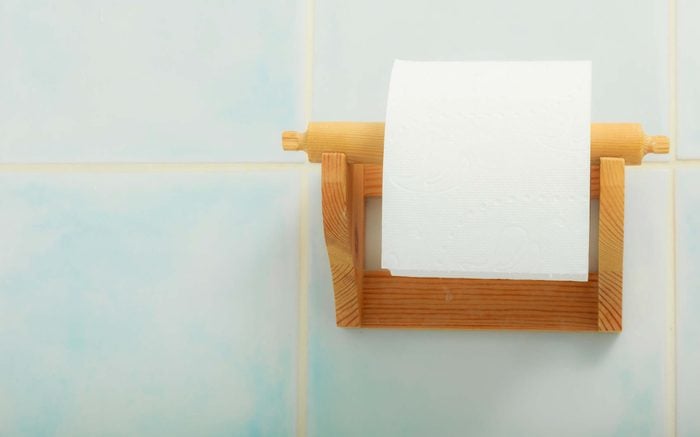 roll of toilet paper on wooden holder