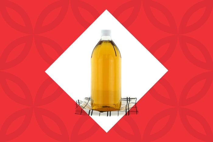 bottle of apple cider vinegar on a kitchen towel