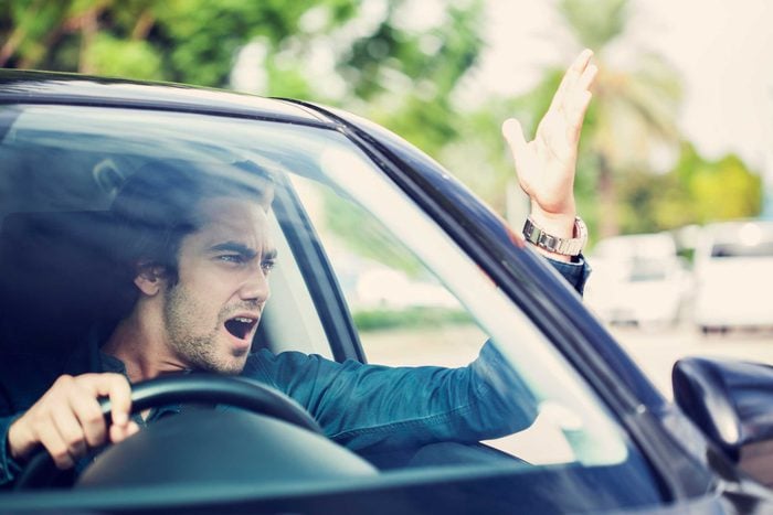 Man driving car yelling and gesturing out of the window