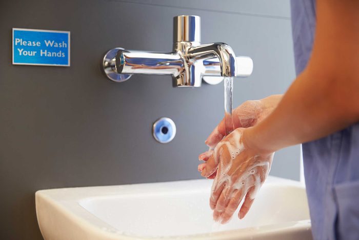 medical professional washing her hands with soap and water