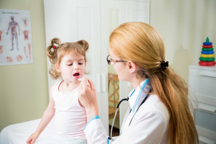 woman pediatrician examining a toddler girl