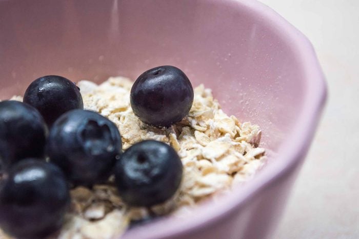 Purple bowl of oatmeal with blueberries.
