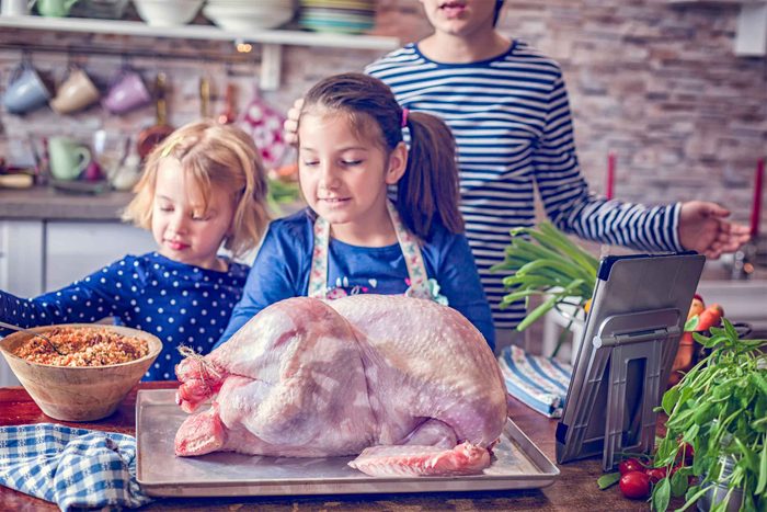 family prepping a raw turkey