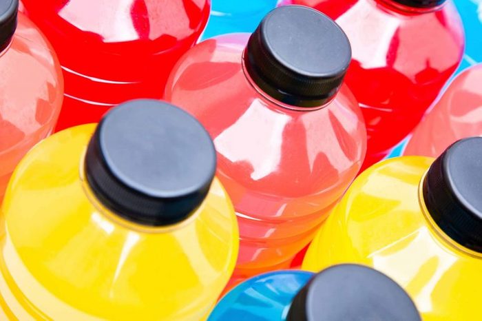 Bottles of red, yellow, and blue sports drinks.
