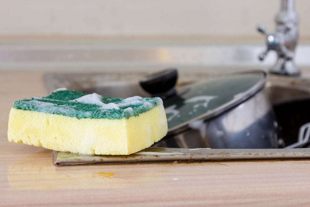 A soapy sponge in the kitchen sink.