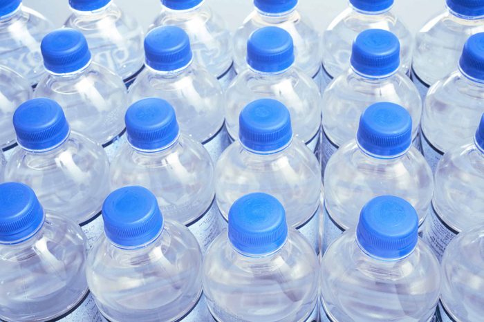 Picture of rows of clear water bottles with blue plastic lids