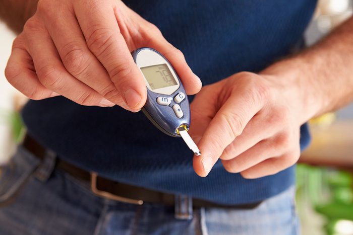 man testing his finger with glucometer