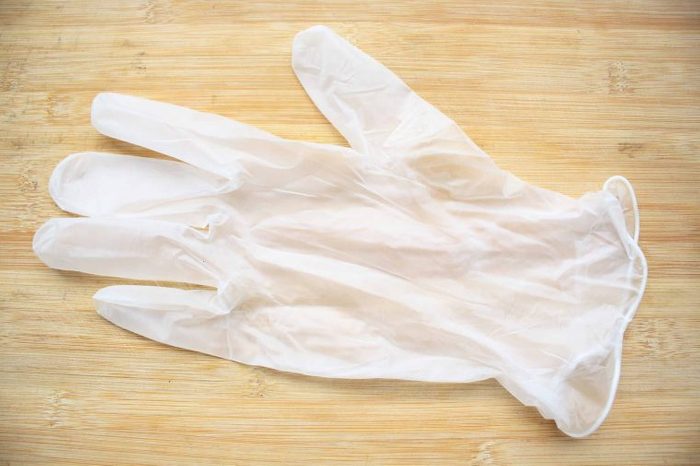 Clear latex glove on a wooden table.