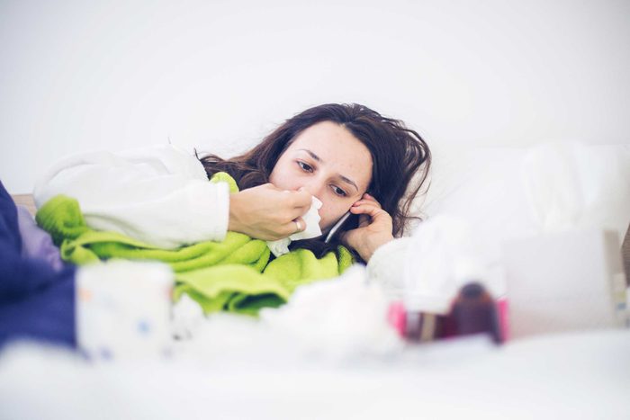 sick woman in bed with tissue