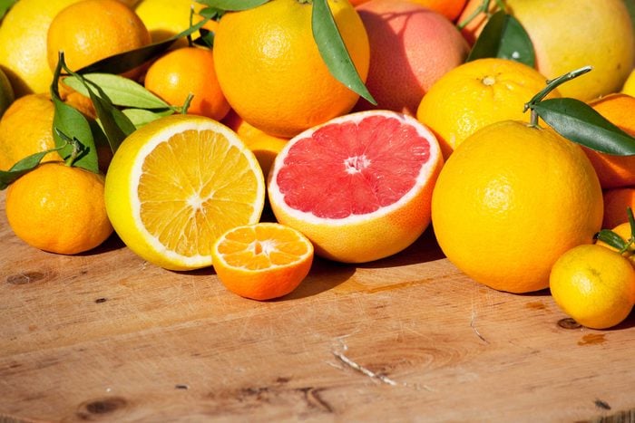 red and yellow grapefruit halves amongst a pile of whole grapefruits 