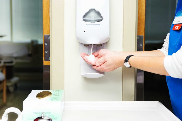 medical professional using hand sanitizer