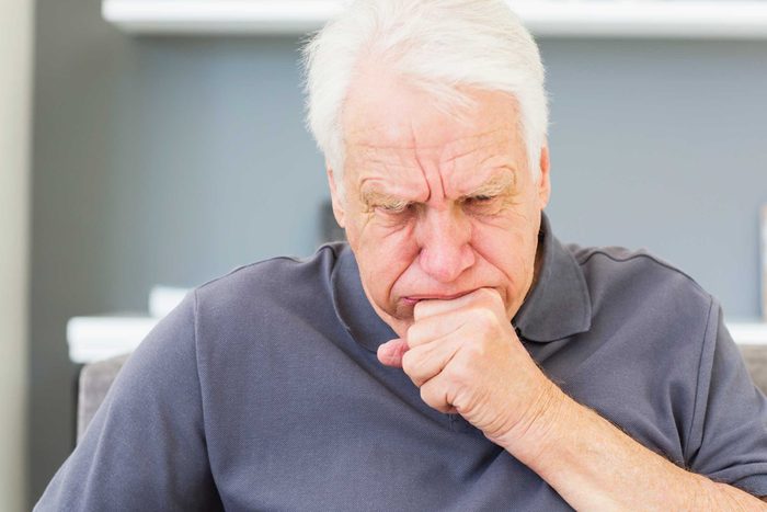 gray-haired man coughing