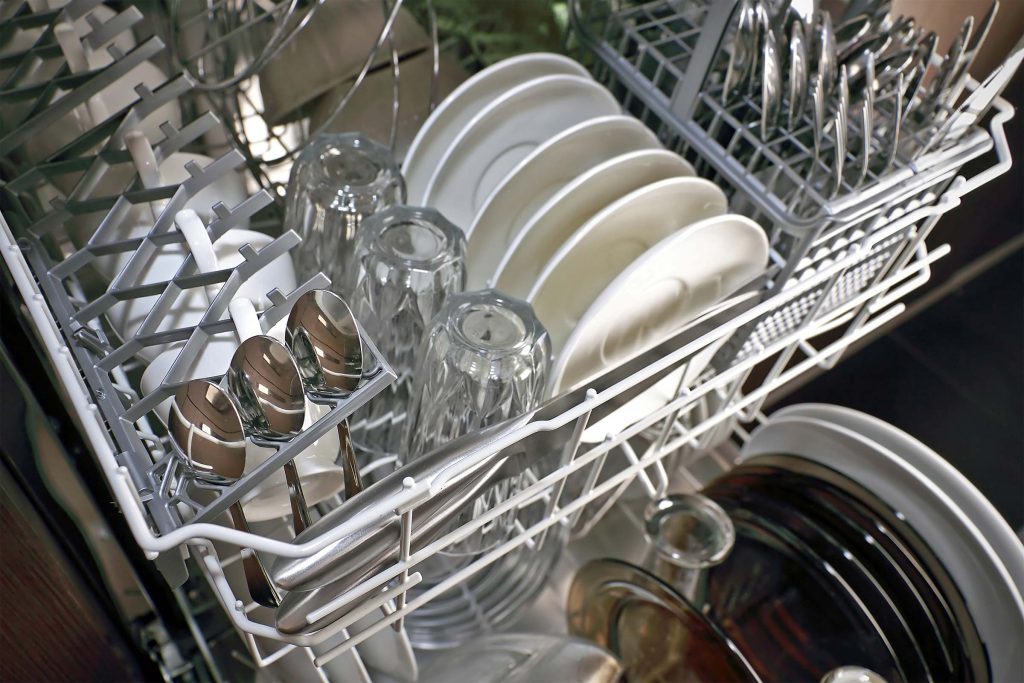 Clean dishes, glasses, and utensils in a dishwasher.