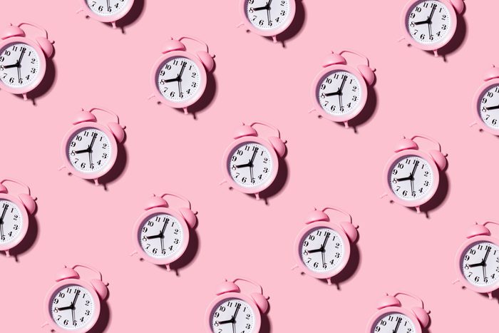 pink alarm clocks on pink background