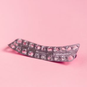 Empty strip of birth control pills on pink background
