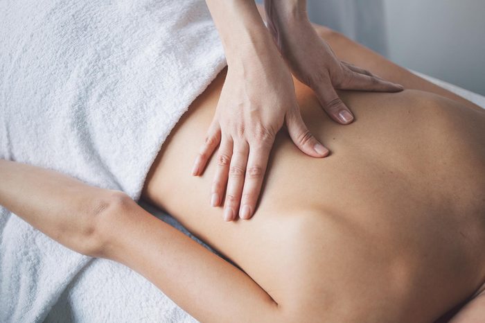 woman's hands massaging another woman's back