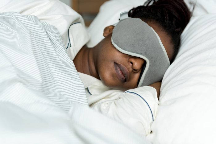 African-American woman with sleep mask in bed