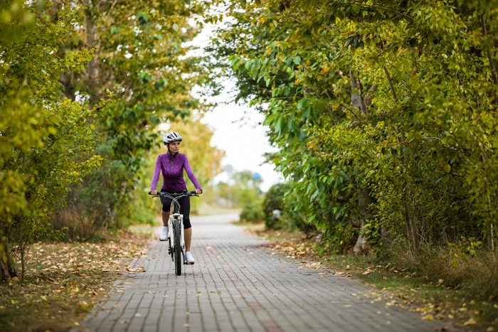 woman on a bike ride through neighborhood nature trail