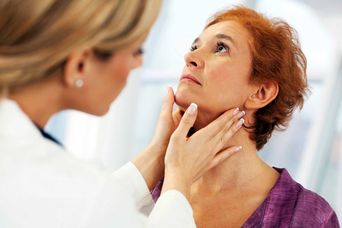 Female doctor checking a woman's neck lymph nodes
