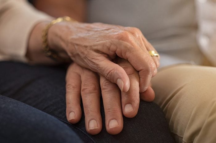 elderly couple holding hands comforting each other