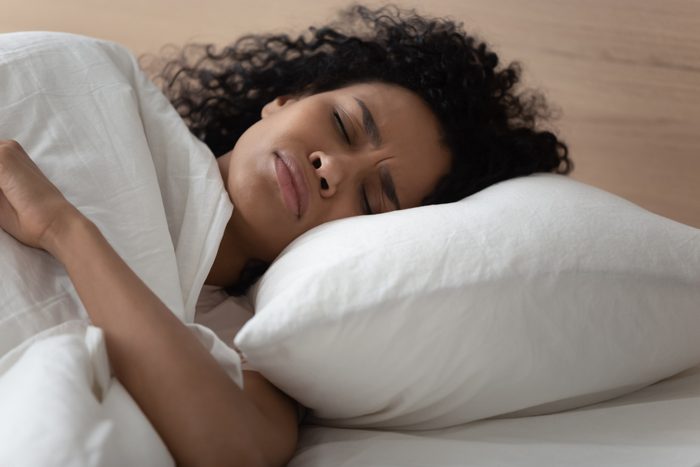 woman lying in bed uncomfortable
