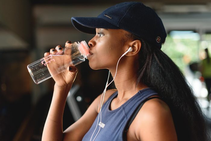 Close-up of woman fitness instructor drinking water 