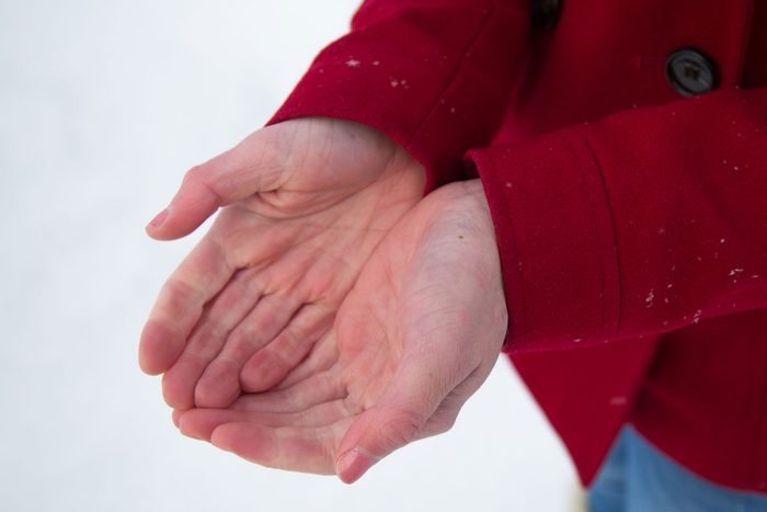 person cupping hands in front of snowy background