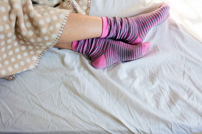 Person wearing cozy pink socks in bed